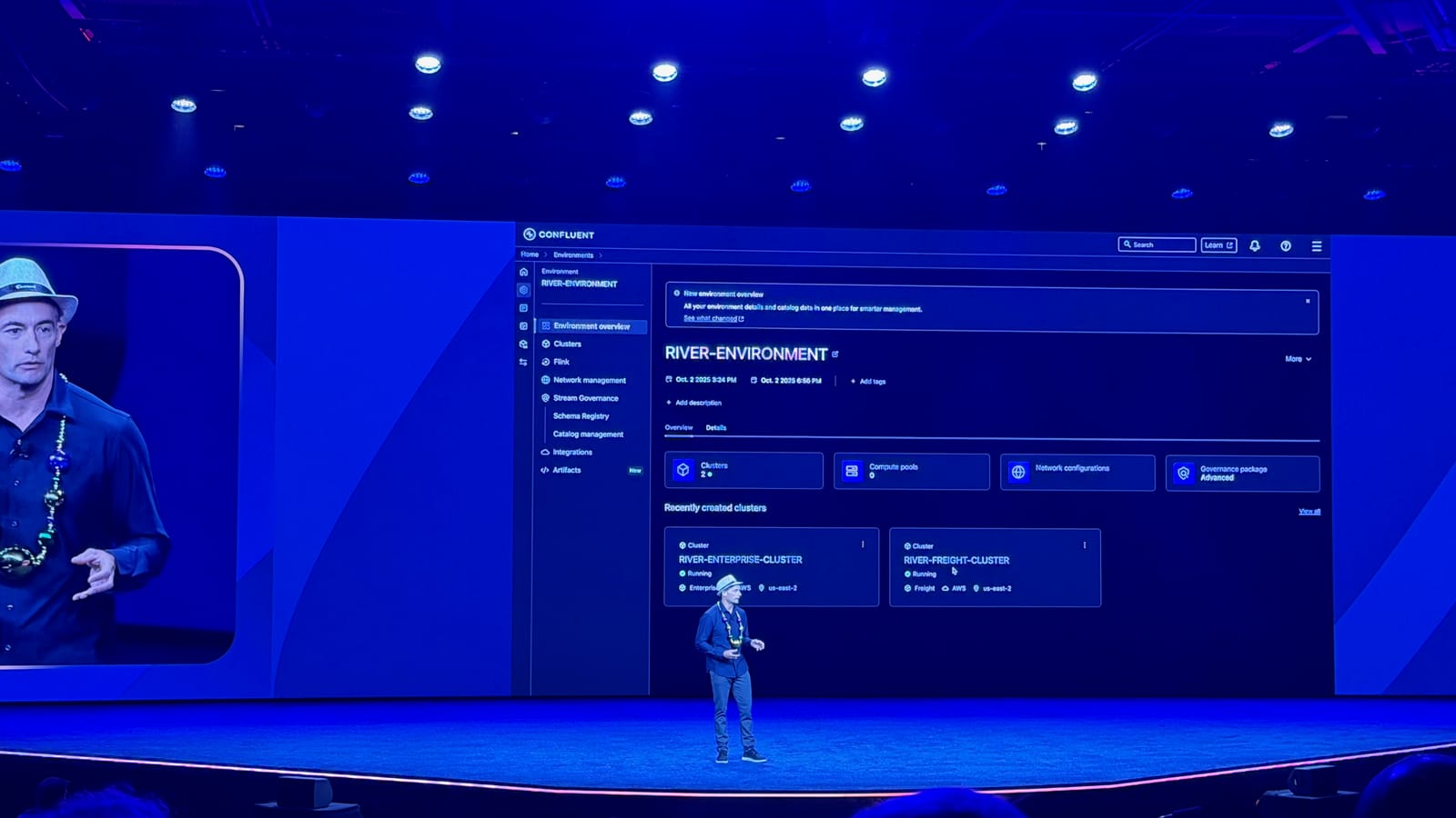 A Confluent keynote speaker on stage demoing the Common Resource Landing Pages environment overview screen on a large projected display.