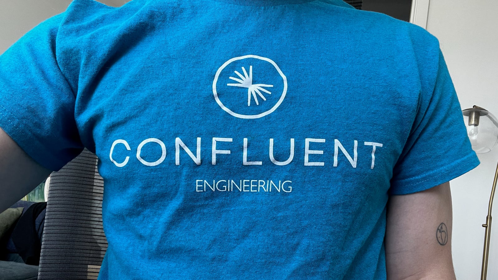 The back of a blue Confluent Engineering t-shirt with the company logo.