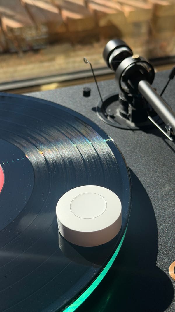 The Sonoff button sitting on a spinning vinyl record on the turntable.