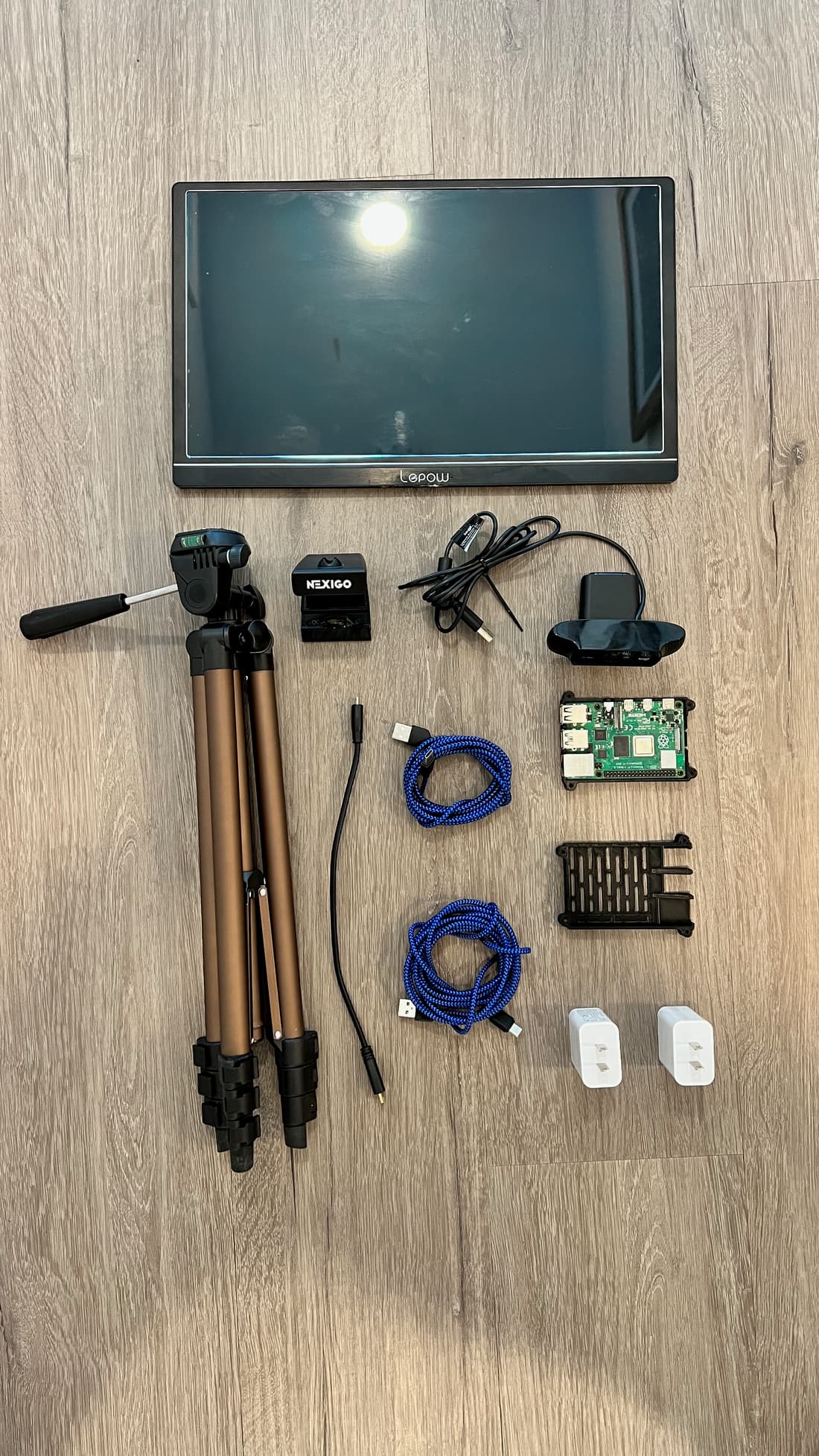 All the components laid out on the floor: monitor, webcam, Raspberry Pi, cables, and power adapters.