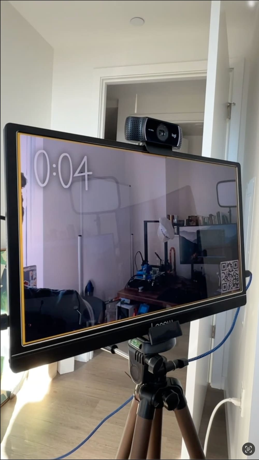 The photo booth's monitor showing a countdown, the webcam mounted on top, and a Discord QR code in the corner of the screen.