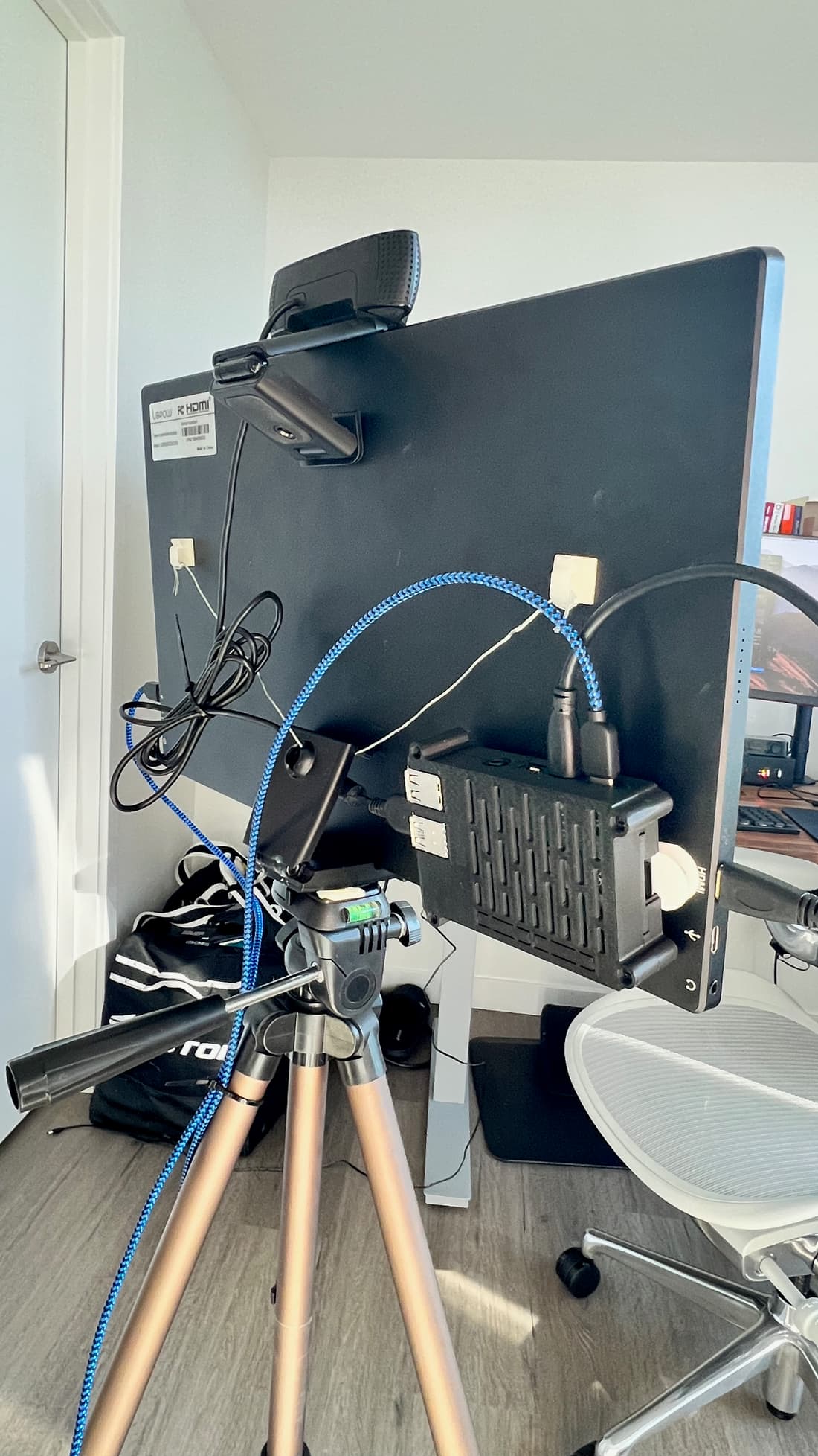 The back of the monitor showing the Raspberry Pi, webcam cable, and power wiring mounted on the tripod.